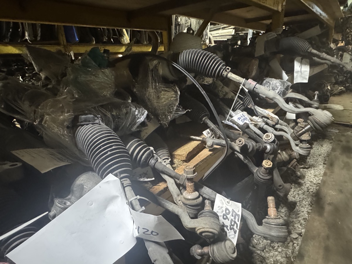 Used BMW steering racks and suspension arms in storage.