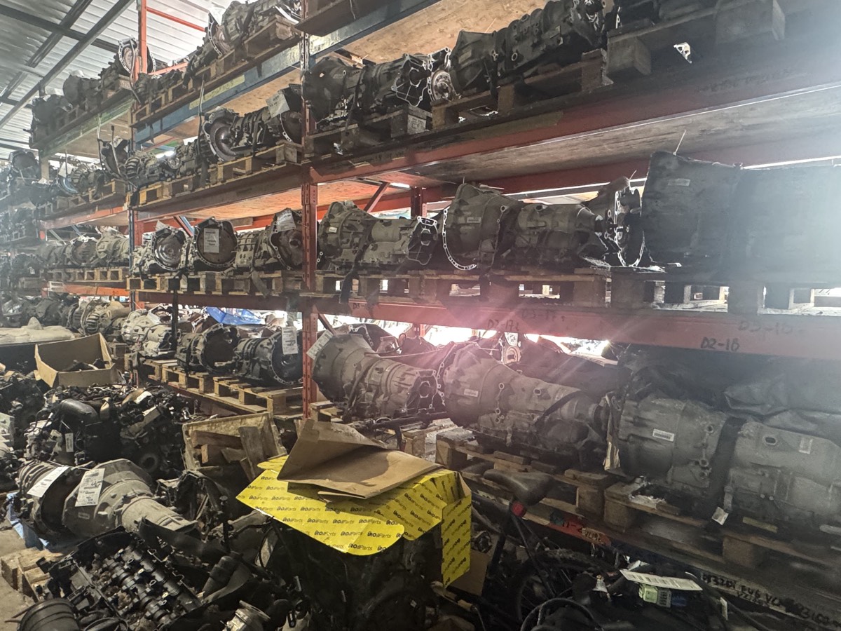 Rows of used BMW transmissions on warehouse shelving.