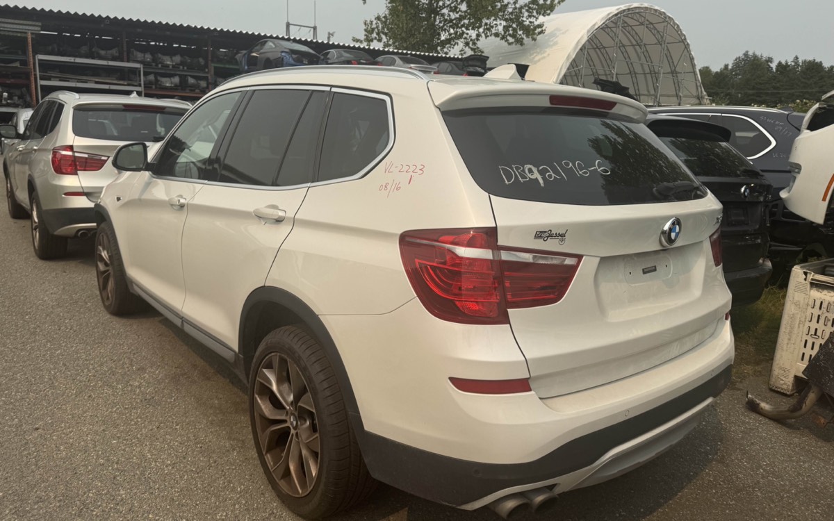 A white BMW X3 parked among other BMWs in the yard.
